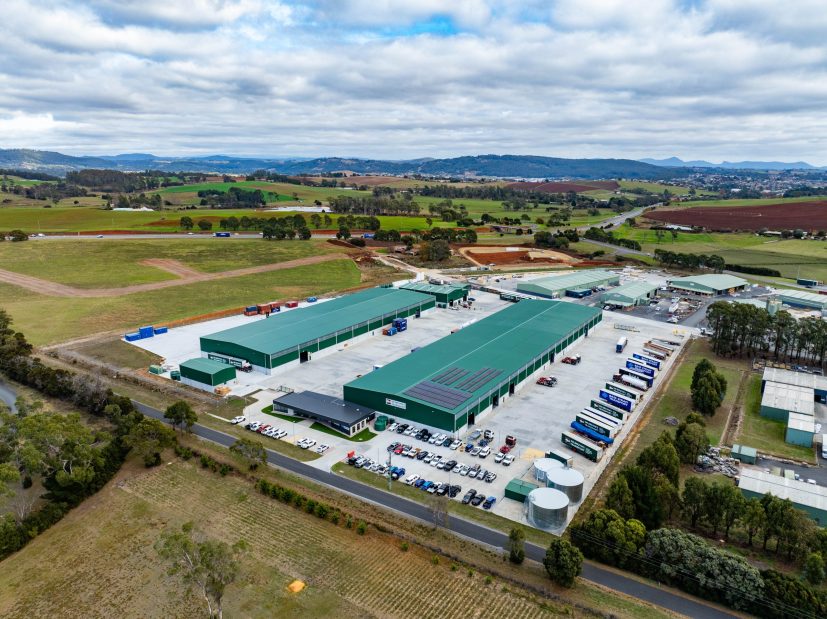 Aerial view of a large-scale DE BRUYNS DEVONPORT warehouse construction site with multiple green-roofed facilities in Tasmania.