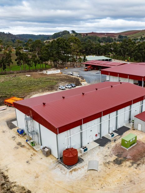 Aerial shot of a rural industrial-grade building in a scenic location.