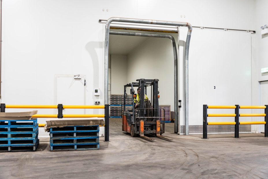 Forklift transporting pallets inside a commercial cold storage warehouse